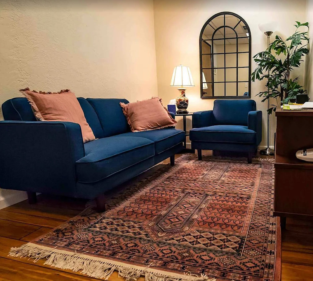 Sitting area with a blue velvet sofa and warm lamp light